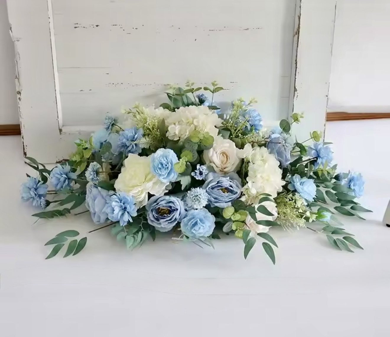 Sinivalkoinen kukka-asetelma